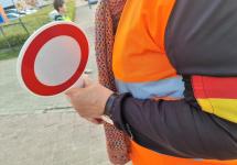 Een gemachtigde opzichter helpt schoolkinderen met oversteken