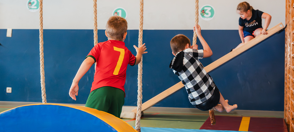 spelende kinderen in de sporthal van De Wissel tijdens een zomerkamp