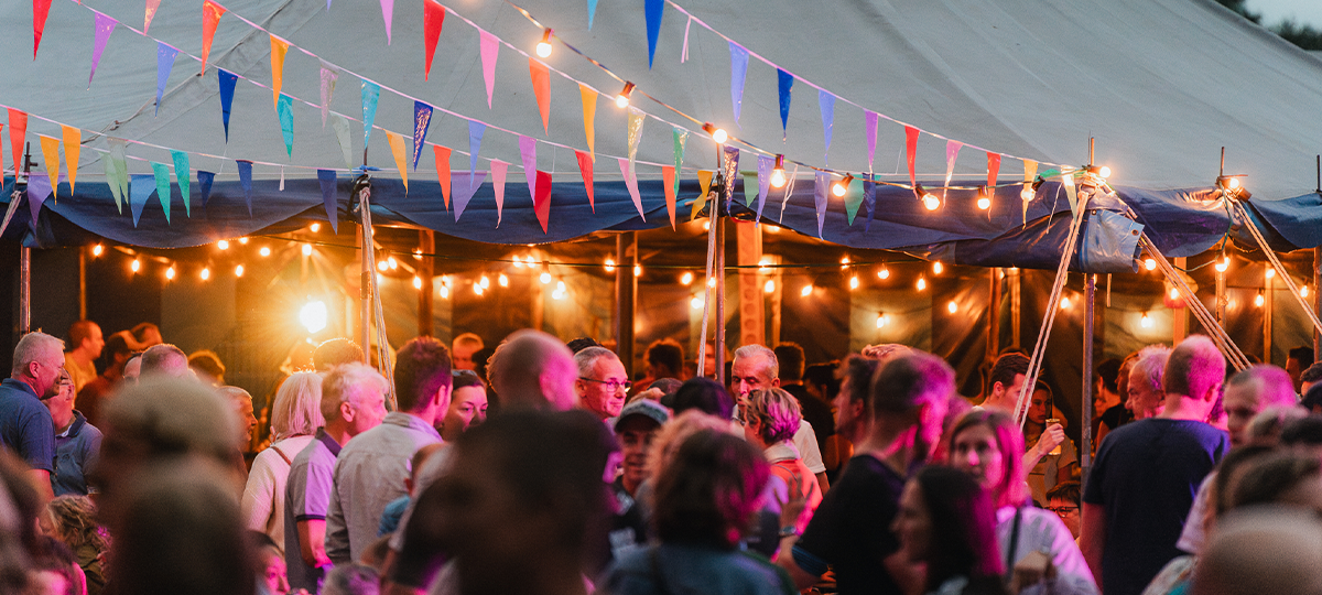 sfeerverlichting en publiek in en rond de feesttent van de Proloogse Baan 2024