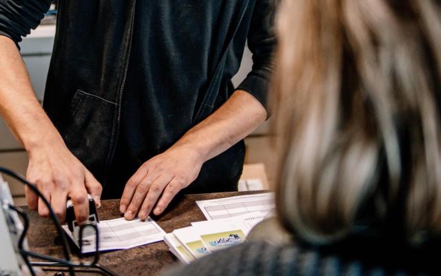een winkelbediende zet een stempel op een spaarkaart tijdens de Wuustwezelse eindejaarsactie van 2022