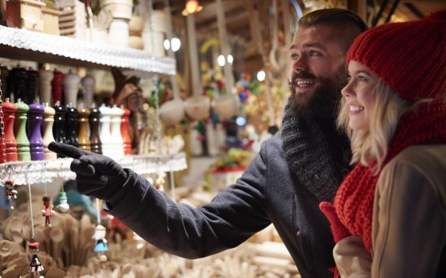een koppel bij een kraam op een kerstmarkt