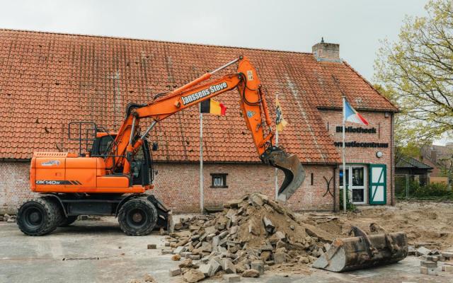 Een graafmachine breekt stenen uit voor de Wuustwezelse bibliotheek