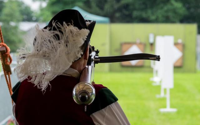 Een man van de Sint Jorisgilde schiet een kruisboog af