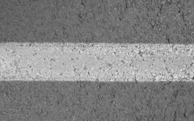 close-up van een witte lijn op asfalt