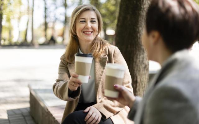 twee vrouwen drinken samen koffie buiten