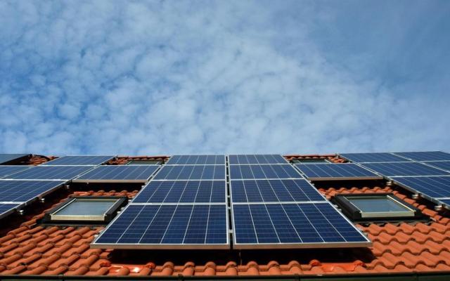 zonnepanelen op een dak met rode dakpannen en enkele vensterramen
