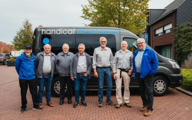 vrijwilligers van de Handicar poseren voor de foto voor een Handicar-camionette aan LDC Ter Wezel