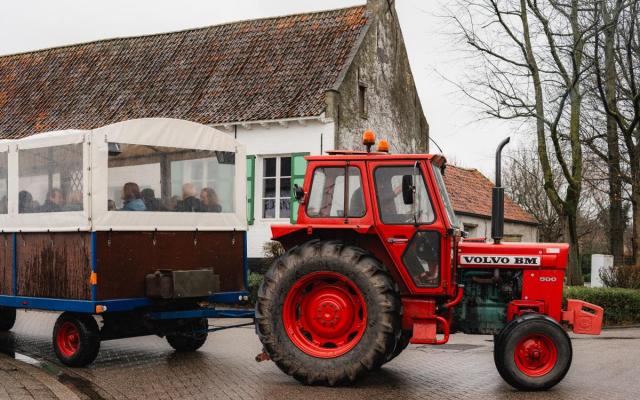 wandelaars in een huifkar tijdens een vorige editie van de groepswandeling 'Dwars door Wuustwezel'