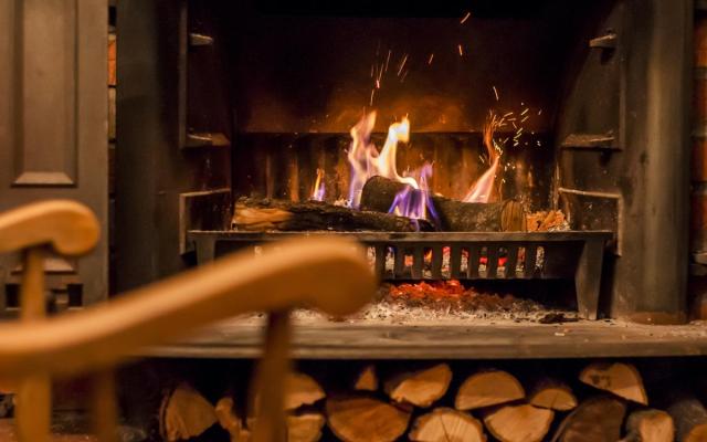 een brandend haardvuur in huis met een voorraadje brandhout