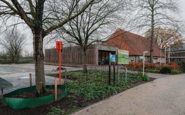 zicht op de bibliotheek en de vernieuwde parking ernaast vanuit de Dorpsstraat