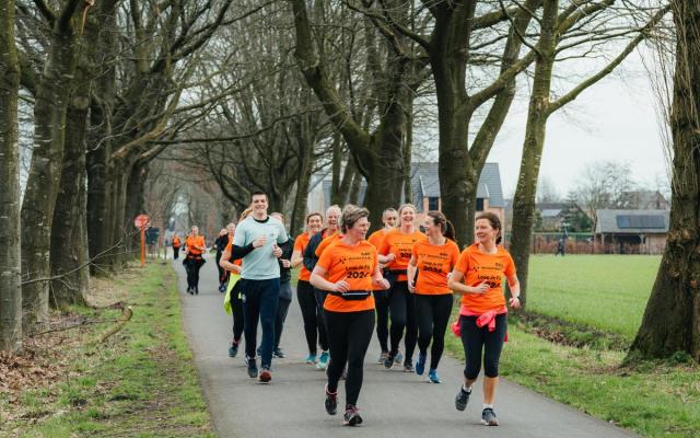 een groepje lopers in oranje t-shirts van GAV tijdens een vorige lessenreeks van Loop je Fit in Gooreind