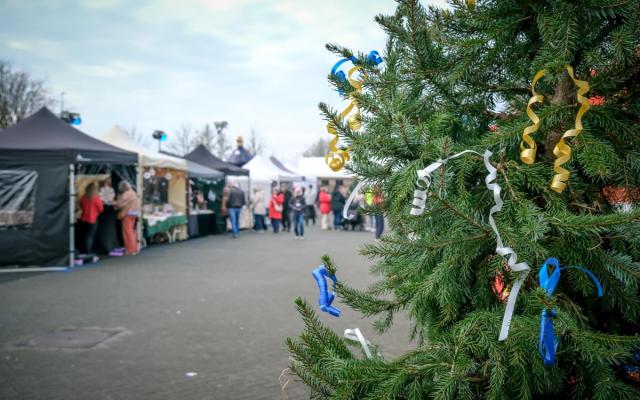 foto van een kerstboom en enkele kraampjes op de achtergrond tijdens Gooreind Kerst 2025 - foto: Wezelopdefoto