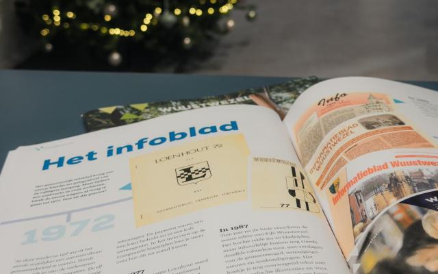 drukproef van het nieuwe infoblad W-tje editie winter 2026, met op de achtergrond een kerstboom