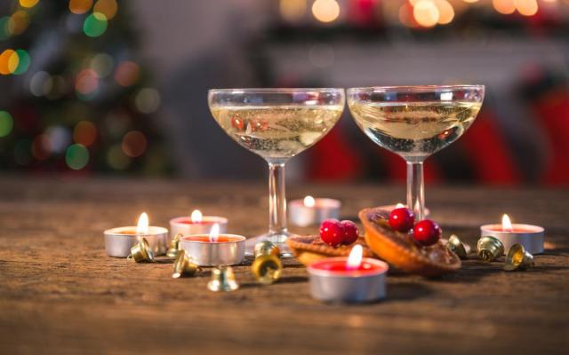 glazen champagne en kaarsjes op een tafel voor een kerstboom