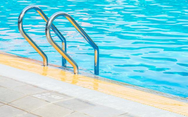 close-up van een trapladdertje in een groot binnenzwembad