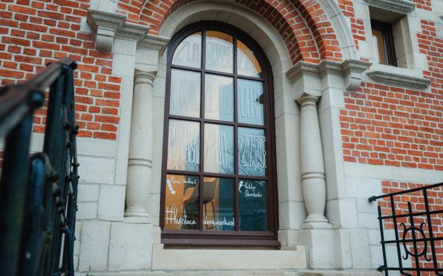 een haiku op een groot venster van het Wuustwezelse gemeentehuis