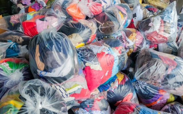 een stapel plastic zakken gevuld met textiel - foto: IGEAN