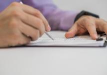 detailfoto van iemand die iets noteert op een document