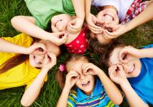 een groepje kinderen liggend op het gras
