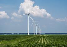een aantal windturbines op een rij in een vlak landschap