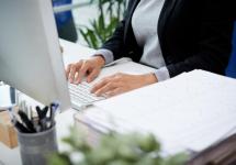 Detailfoto van een persoon die aan een computer werkt