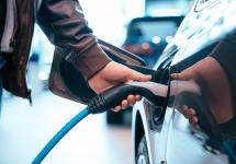 iemand die een lader in een elektrische auto steekt