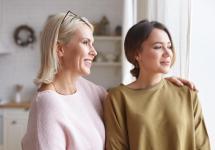 moeder en dochter kijken glimlachend uit het raam