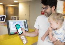 Een man scant zijn UiTPAS-app voor een UiTPAS-zuil om een puntje te sparen