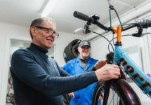 Herman en Marcel sleutelen aan een kinderfiets in de Fietsbieb van Wuustwezel