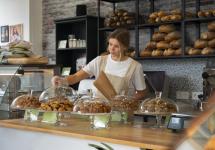 een vrouw aan de toog van een bakkerij - stockfoto