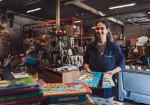 een medewerker van de Kringwinkel neemt gedoneerde strips en kinderboeken in ontvangst