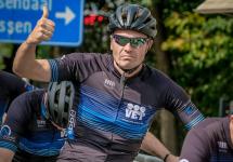 een wielrenner in outfit van team VET met z'n duim omhoog