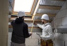twee mannen met werfhelmen in een onafgewerkt huis