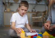 een autistische jongen speelt met speelgoed