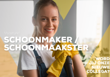 een schoonmaakster steunt op een bezemsteel en lacht naar de camera