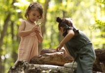 kinderen met een loep op schattenjacht in het bos