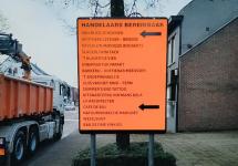 oranje verkeersbord met pijlen en een overzicht van de handelaars in het centrum