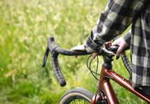 foto van een man die zijn gravelfiets vasthoudt 