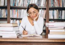 een vrouw schrijft in een notitieboek in een bibliotheek