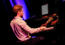 iemand speelt piano op het podium in GC Kadans