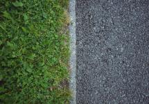 foto van grond met links gras en rechts grijze steentjes