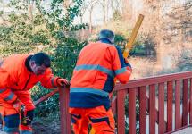 Twee schrijnwerkers die een brug waterpas aan het zetten zijn.