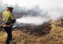 Een brandweerman in actie tijdens de brand op het Groot Schietveld