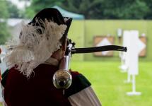 Een man van de Sint Jorisgilde schiet een kruisboog af
