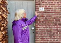 een gemeenschapswacht staat voor een woning met huisnummer 49