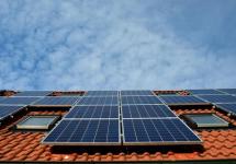 zonnepanelen op een dak met rode dakpannen en enkele vensterramen